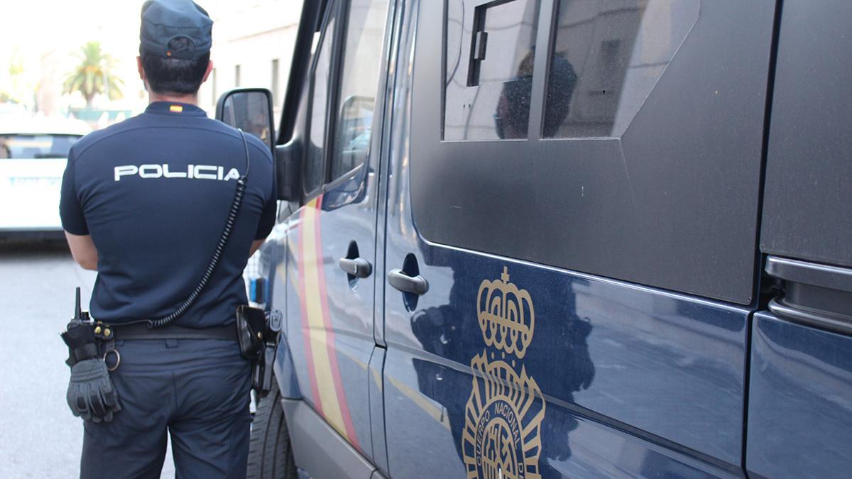 Un agente de la Policía Nacional, junto a un furgón, en una calle de Valencia
