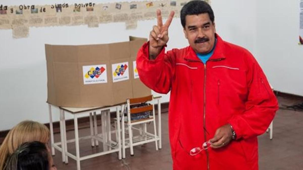 Maduro hace el signo de la victoria antes de votar en un centro de Caracas, este domingo.