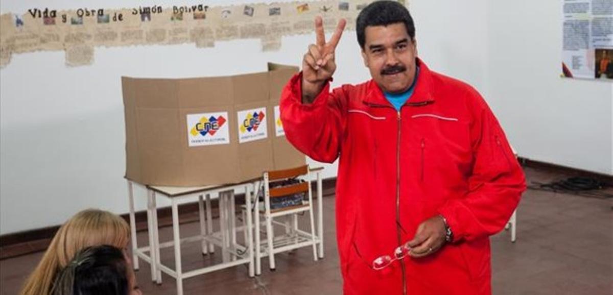 Maduro fa el signe de la victòria abans de votar en un centre de Caracas, aquest diumenge.