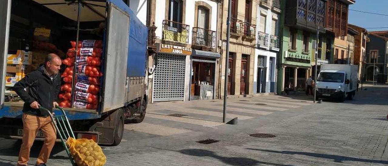 En primer término, Arturo Vázquez carretando patatas en la calle San Antonio. Al fondo, un furgón con autorización para carga y descarga.