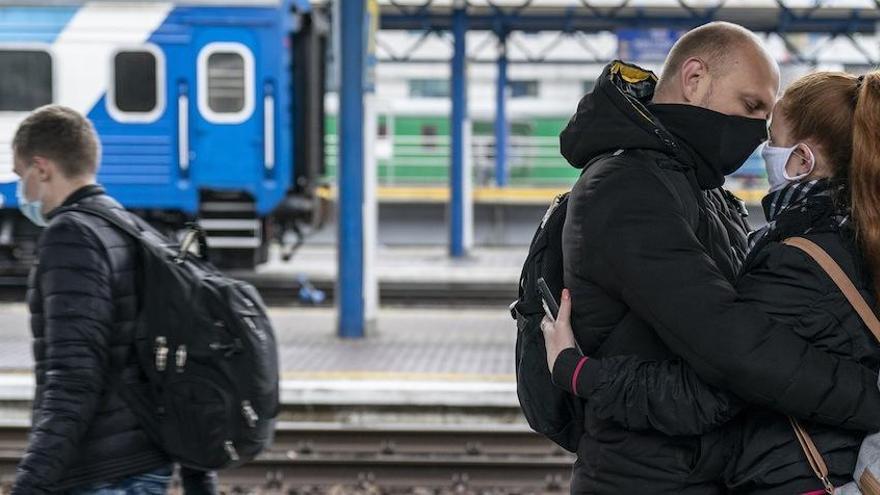 Una pareja se abraza sin aliento en una estación de Ucrania.