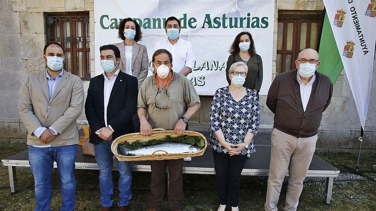 Íñigo Justo Fernández Amantegui, con el campanu de Asturias, pescado en el Narcea, durante la subasta en Cornellana, rodeado de autoridades locales.