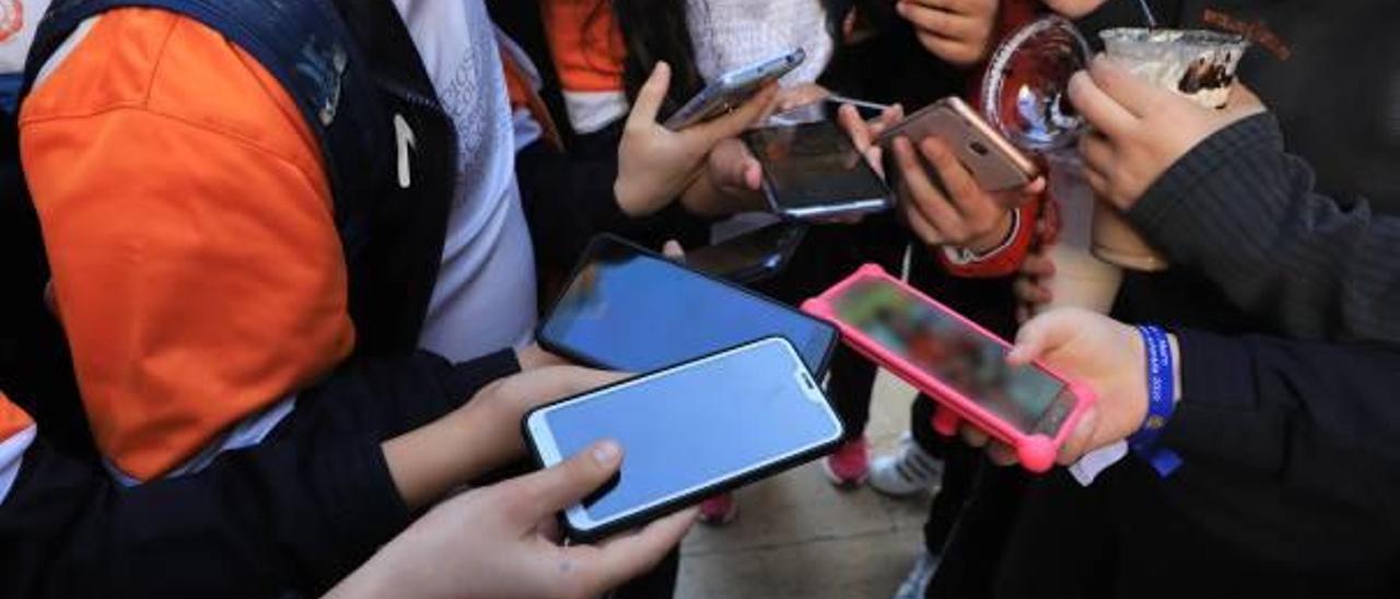 Un grupo de jóvenes con sus teléfonos móviles en la mano en una imagen de archivo.