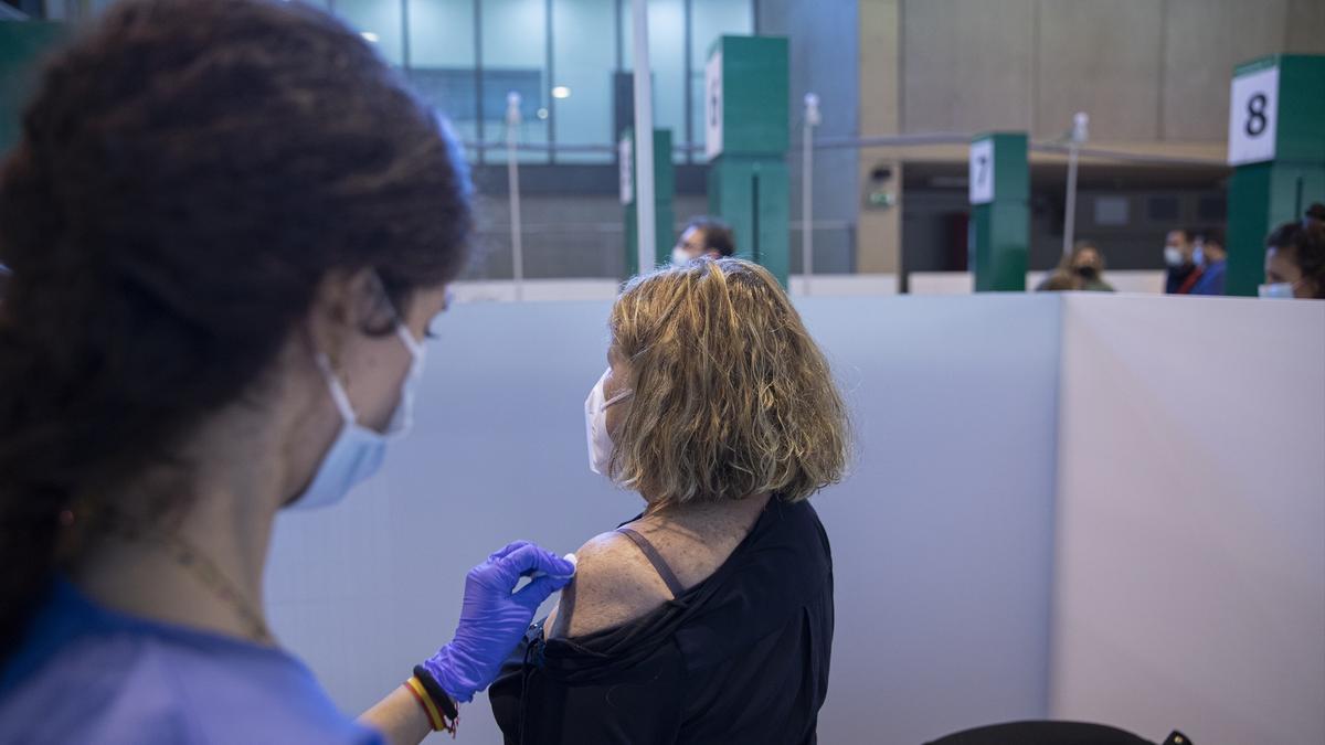 Una sanitaria vacuna a una mujer.