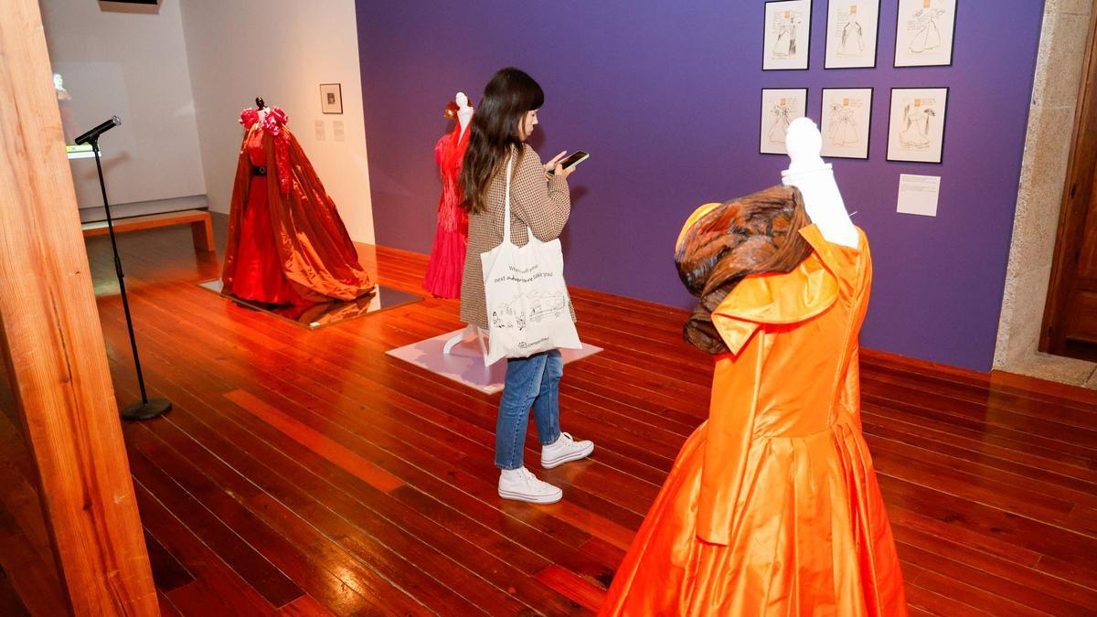 Una visitante paseando por la exposición 'O gardaroupas da música' en Compostela