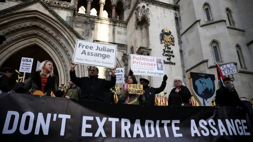 Partidaris de Julian Assange, amb una pancarta, a l’exterior de la Cort de Justícia a Londres.  | REUTERS / HENRY NICHOLLS
