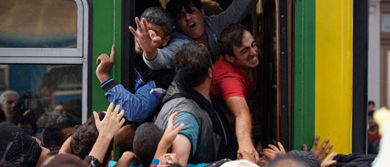 Refugiados subiendo a un tren en Budapest.// EFE