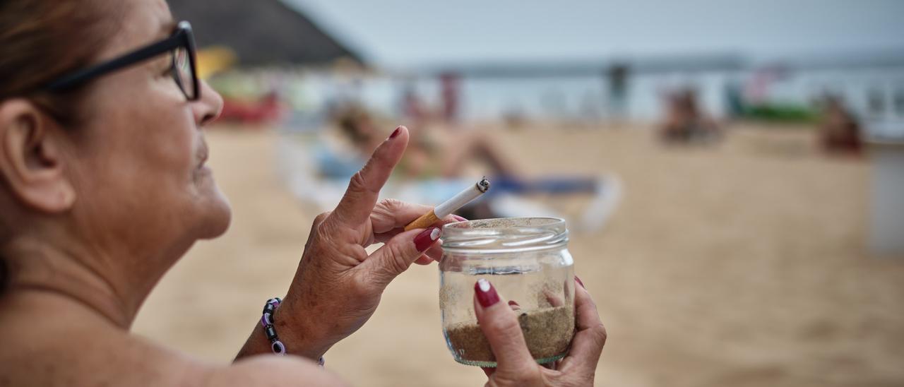 Una bañista de la playa de Las Teresitas se fuma un cigarro.