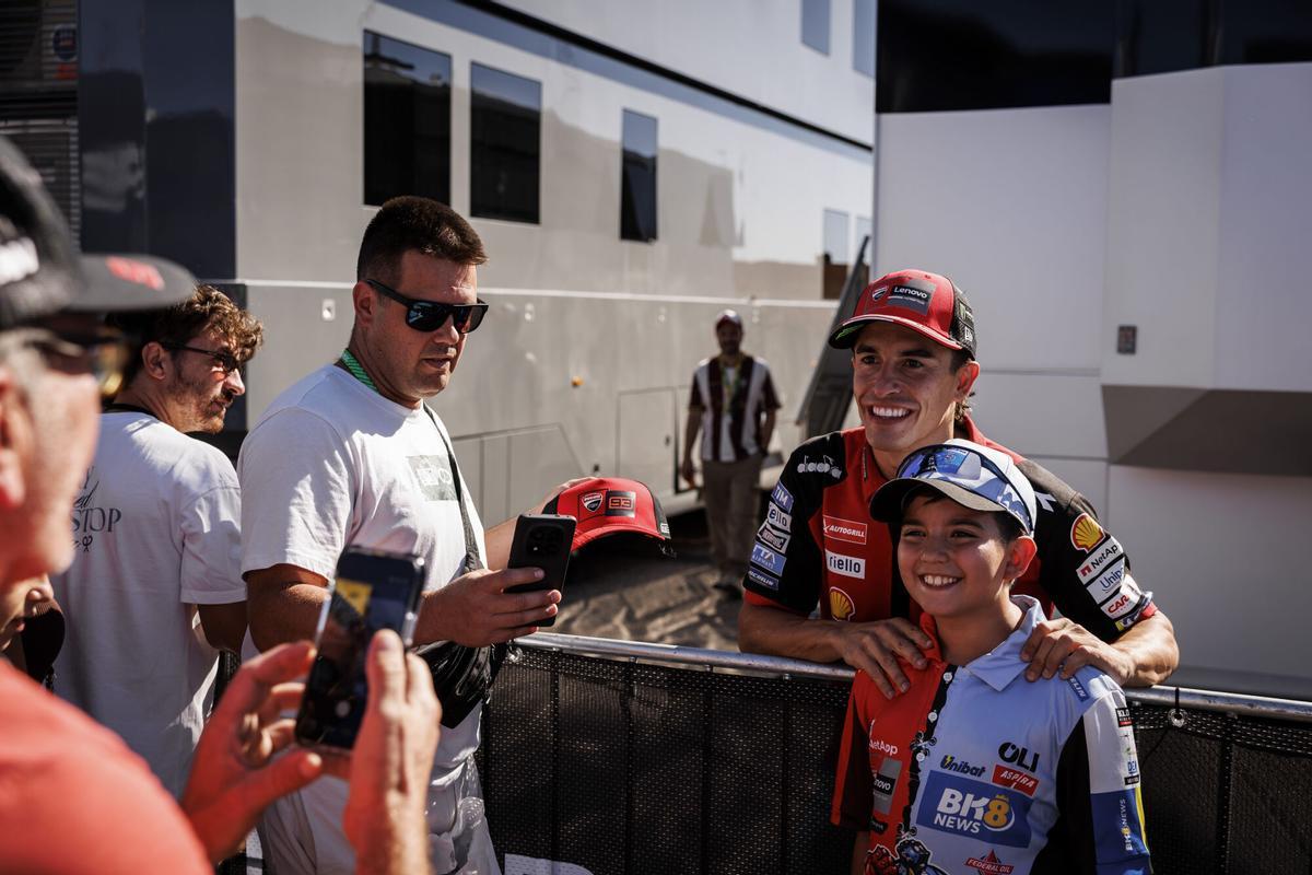 Marc Márquez se fotografía con un joven aficionado en la puerta de su caravana.