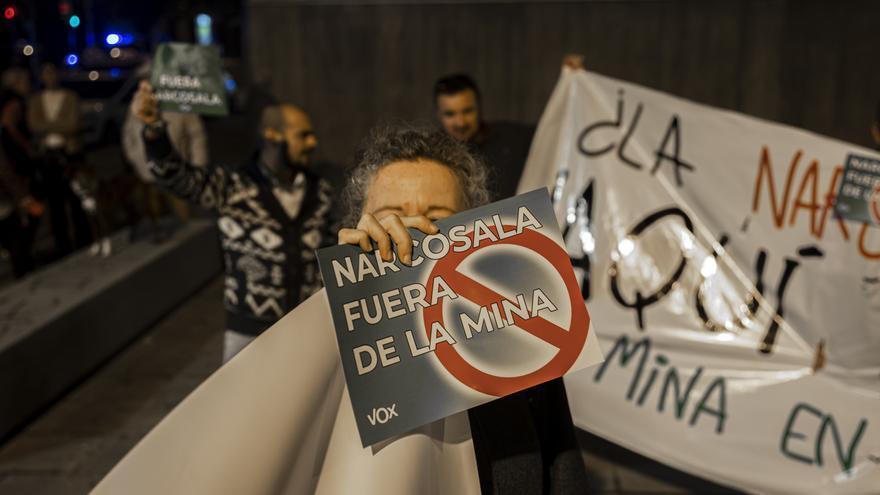 Una manifestante exhibe un cartel firmado por Vox contra la sala de venopunción de La Mina.