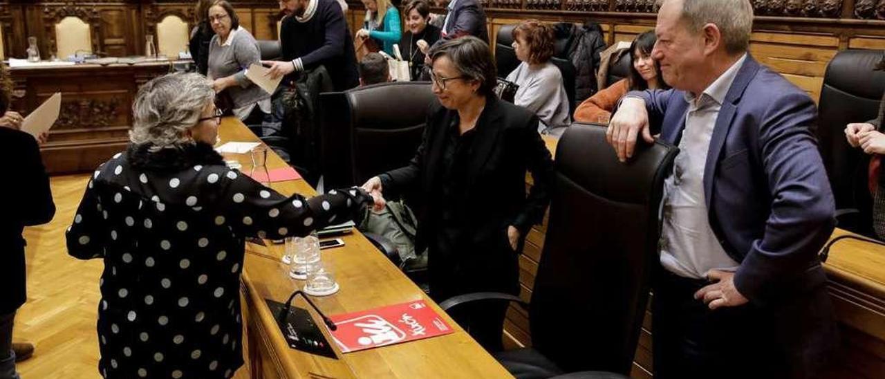 Ana González (PSOE) saluda a Yolanda González Huergo (Podemos-Equo) ante la mirada de Aurelio Martín (IU) al finalizar la sesión plenaria donde se aprobaron los presupuestos municipales para 2020.