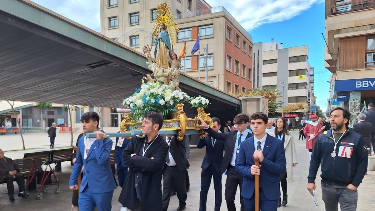 Integrantes de la Congregació de Lluïsos portan a hombros la imagen de la Puríssima del Poble.