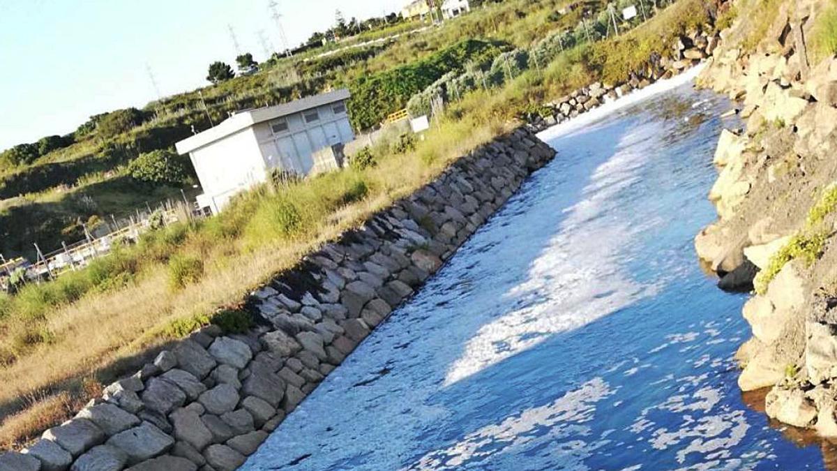 Espuma en el río que desemboca en la playa de Sabón, este martes. |   // LA OPINIÓN