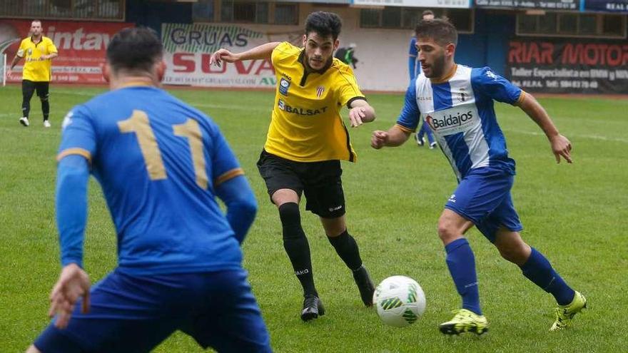 Álex Arias conduce el balón ante un jugador de L&#039;Entregu, ante la mirada de Matías .