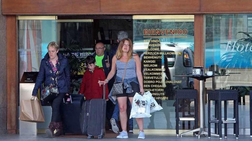 Un grupo de turistas salen de un hotel gallego, ayer, tras las vacaciones de Semana Santa.