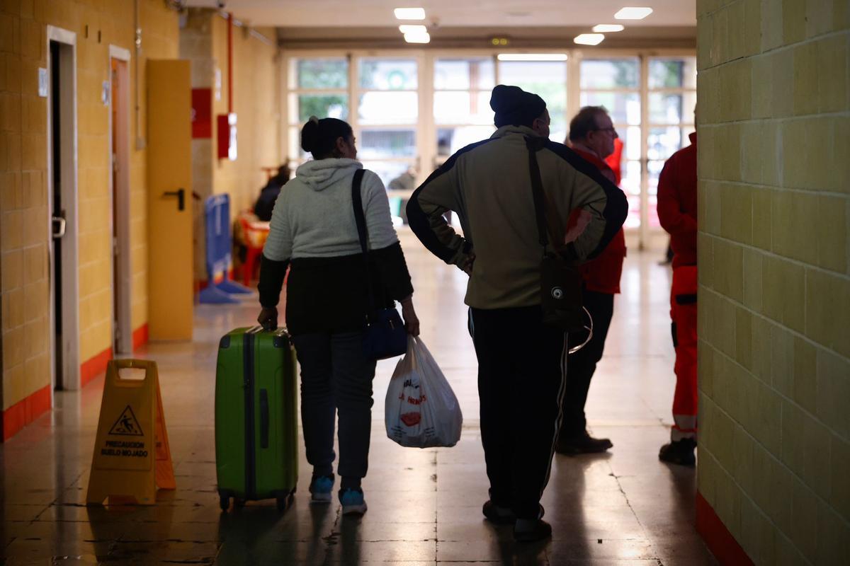 Una pareja con sus pertenencias en el pabellón.