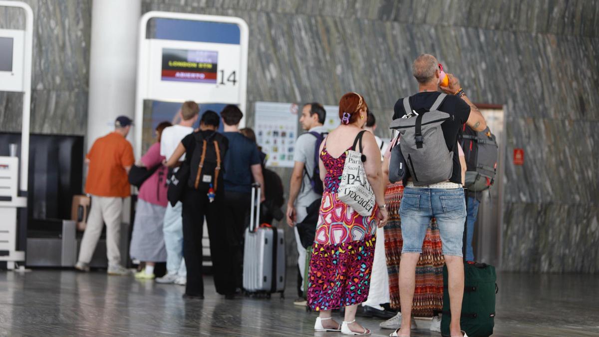Fila de pasajeros esperando a facturar su equipaje, hoy en el aeropuerto de Zaragoza.