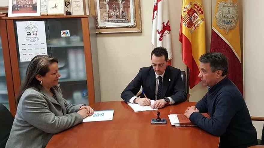 El alcalde Luciano Huerga firmando el convenio con la responsable de la entidad labroal y el concejal de Educación Antonio Vega.
