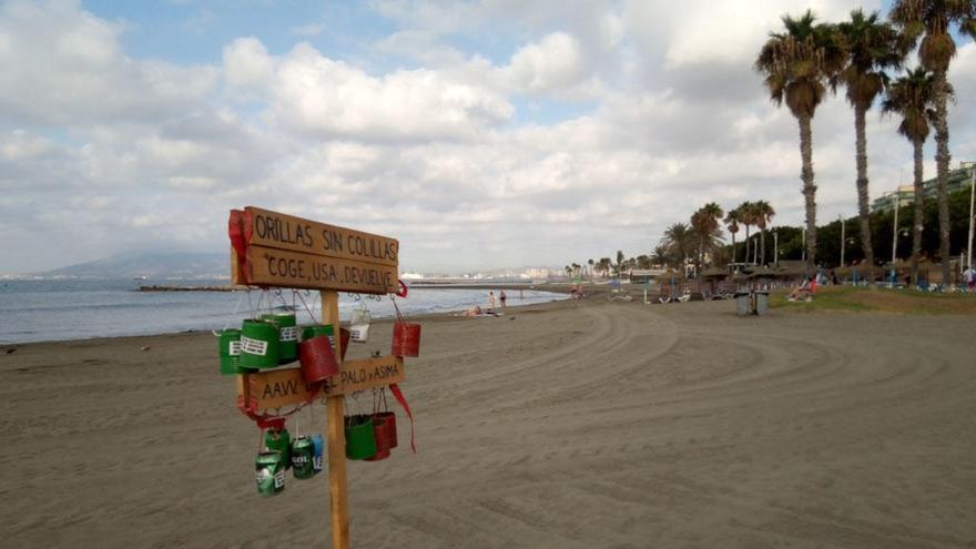 Este era el aspecto hace unos días de la playa del Palo, donde todavía se encuentran las perchas instaladas por la Asociación de Vecinos del Palo para que los bañistas no usen la playa de cenicero y echen mano de las latas.