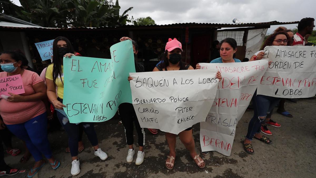 Familiares de presos muestran carteles de protesta en los exteriores de la cárcel de Santo Domingo de los Tsáchilas en Ecuador.