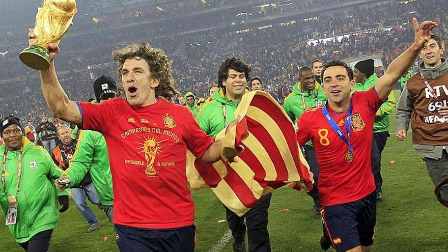 Puyol y Xavi levantan la Copa y la bandera catalana.