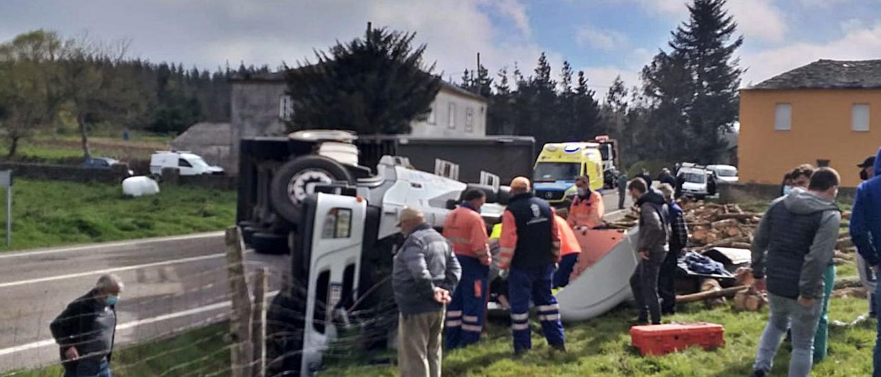 Bomberos, voluntarios y vecinos en torno a la cabina. | LNE