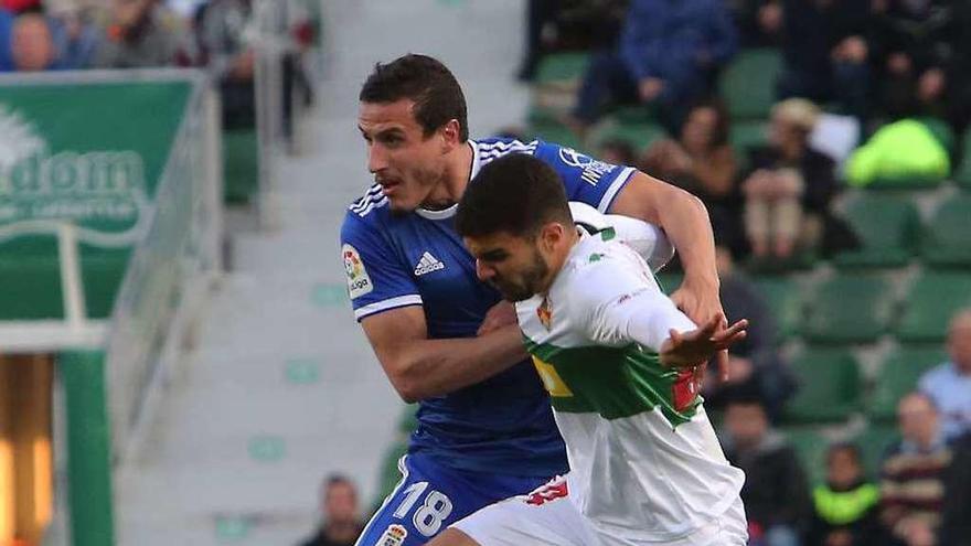 Christian Fernández, del Oviedo, lucha por un balón con Yacine, del Elche.