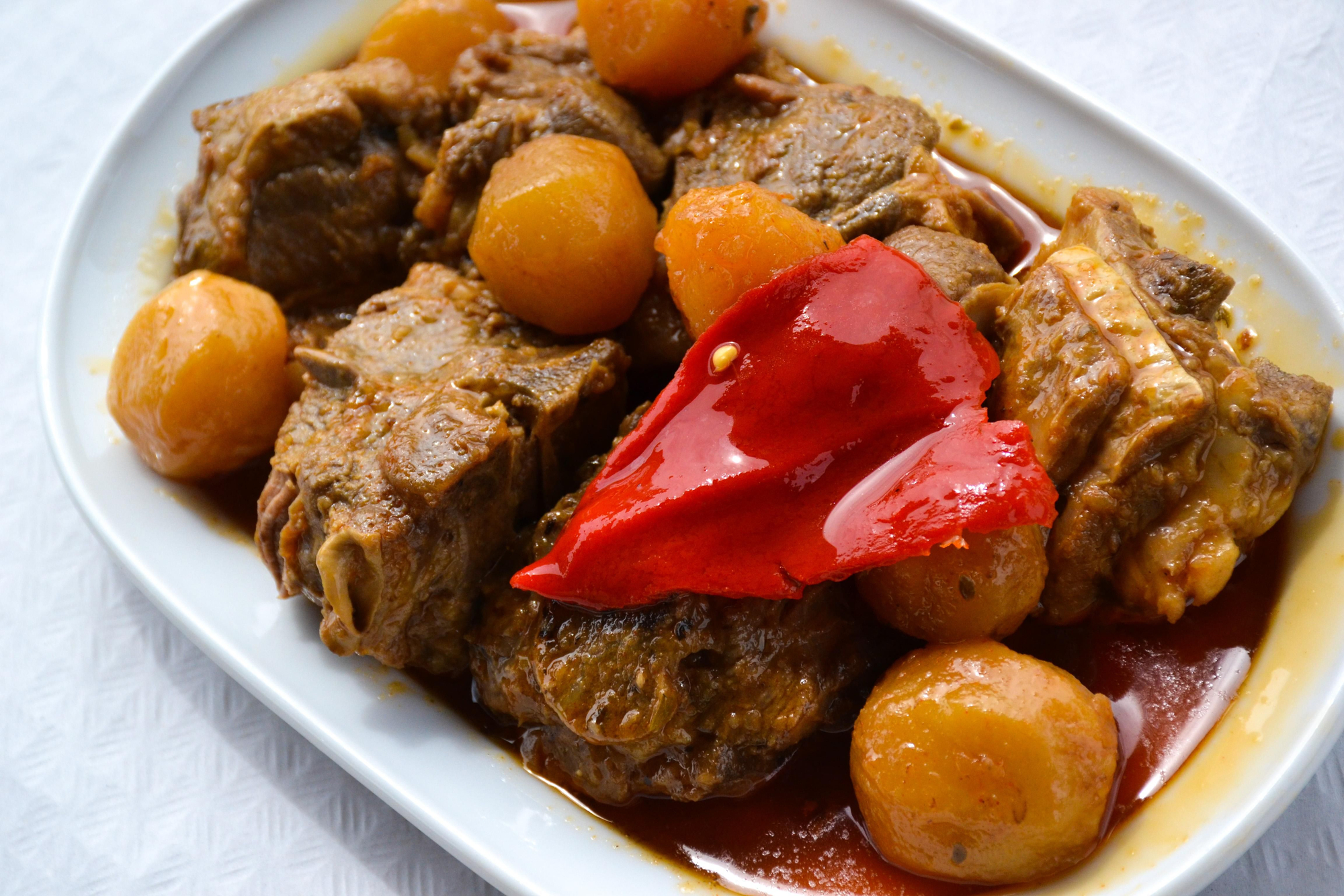 Cabrito guisado acompañado de pimiento y patatinos.