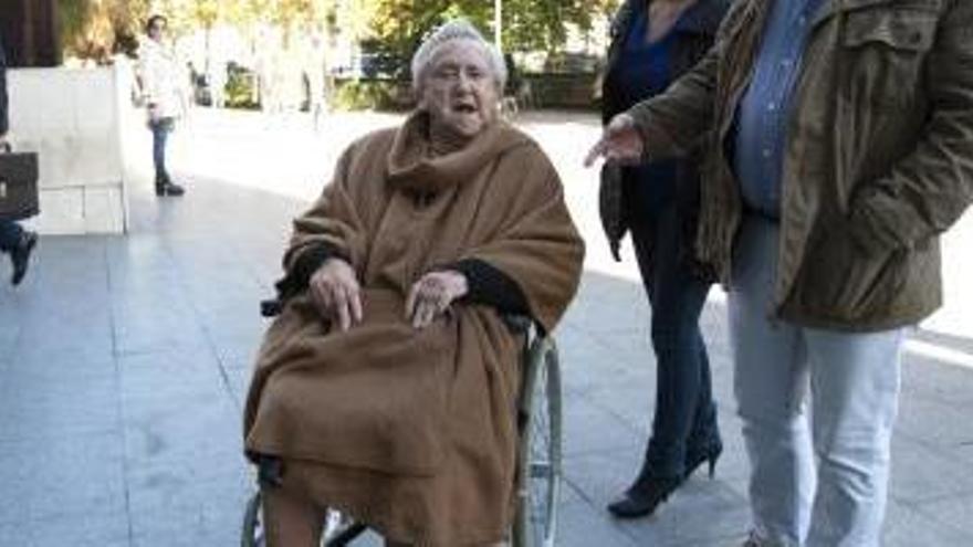 Doña Marita en silla de ruedas a su llegada a la Ciudad de la Justicia.