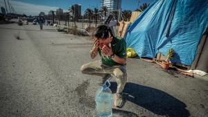 Luis se asea en el campamento que el Ayuntamiento prevé desalojar junto a la playa de la Nova Mar Bella, en Barcelona.