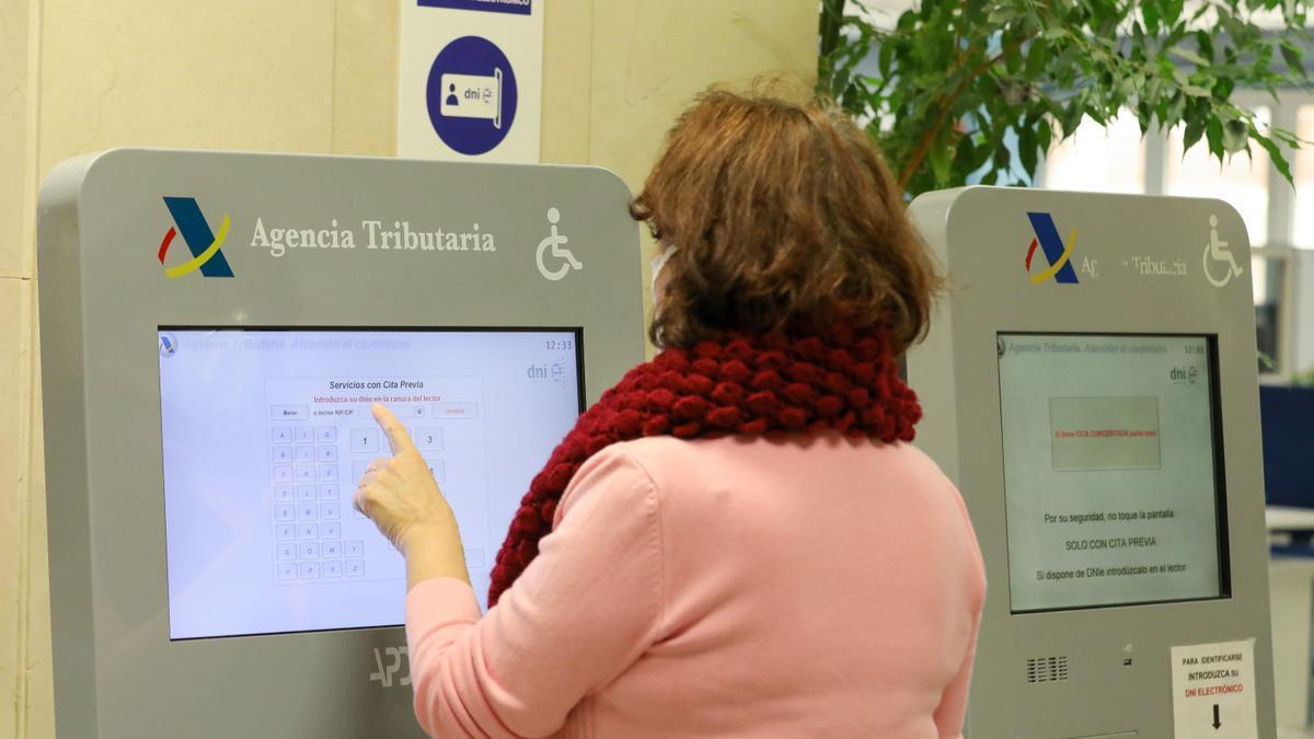 Una mujer coge cita para la declaración de la renta.