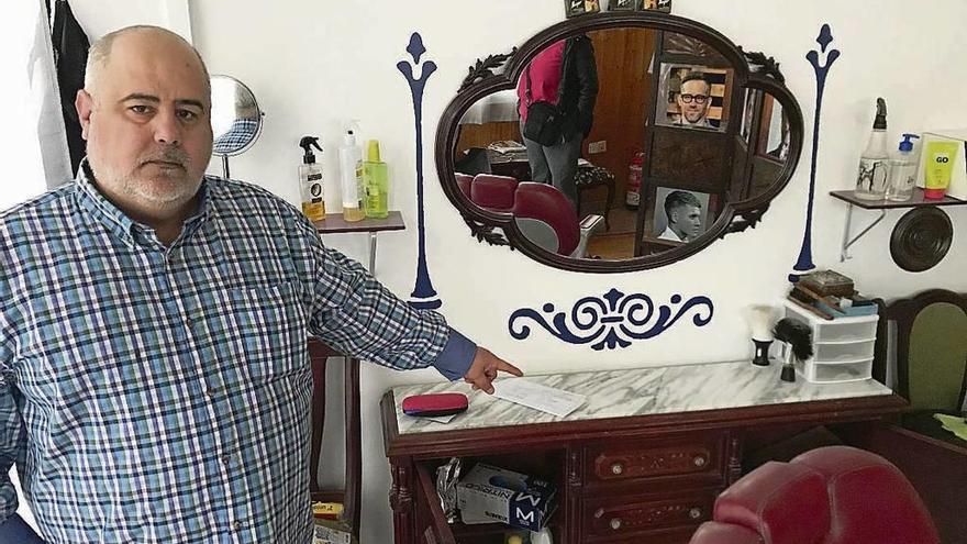 Julián Armando Ortiz muestra el interior de su barbería tras el robo. // Muñiz