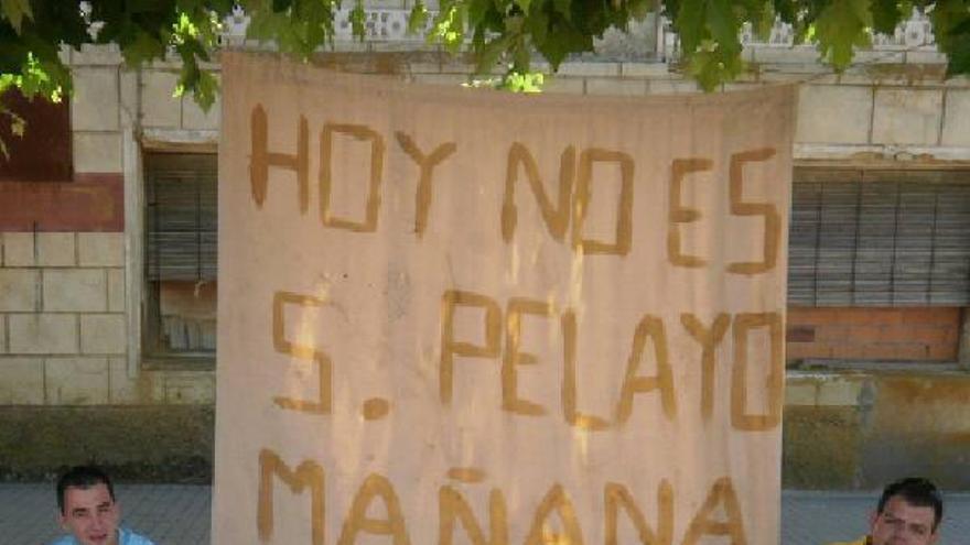 Dos jóvenes junto a la pancarta colocada ayer en Cañizo.