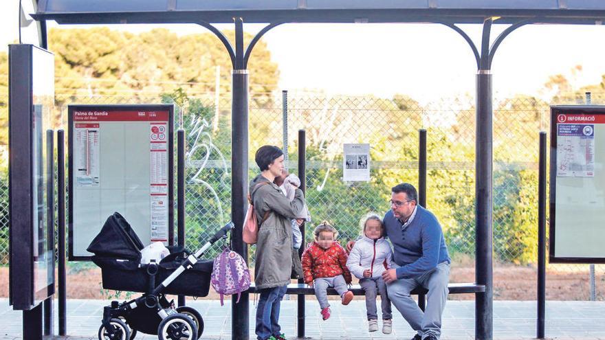 Marc López e Inma Mateu, con su hija Emma, de 3 años; Marta, de 2 años, y Jordi, de 3 meses, ayer, en la parada de autobús.