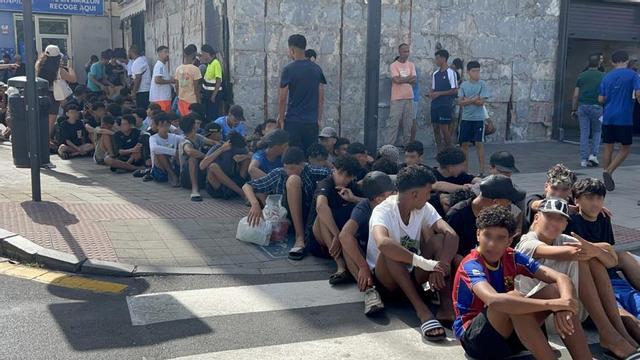 Un grup de menors esperen per ser identificats en una comissaria de la Policia Nacional a Ceuta. | GABRIELA SARDÁ NÚÑEZ / EUROPA PRESS