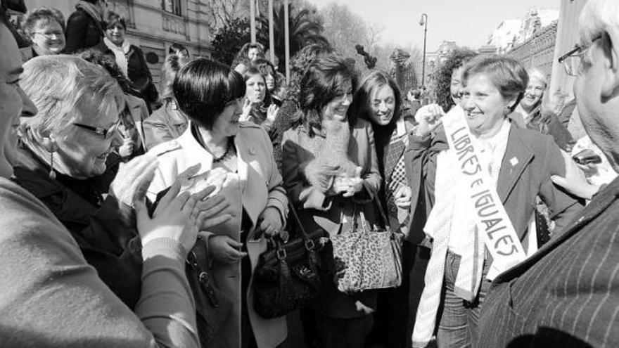 M.ª José Ramos, rodeada de mujeres que la aplauden, entre las que puede verse a Paloma Sainz y a Ana Rosa Migoya (centro). A la derecha, Álvarez Areces.