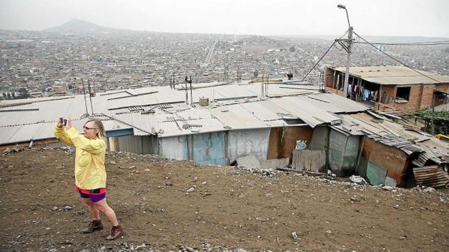 Una turista d&#039;Estats Units es fa una foto amb el fons de l&#039;estesa de barraques de Villa El Salvador