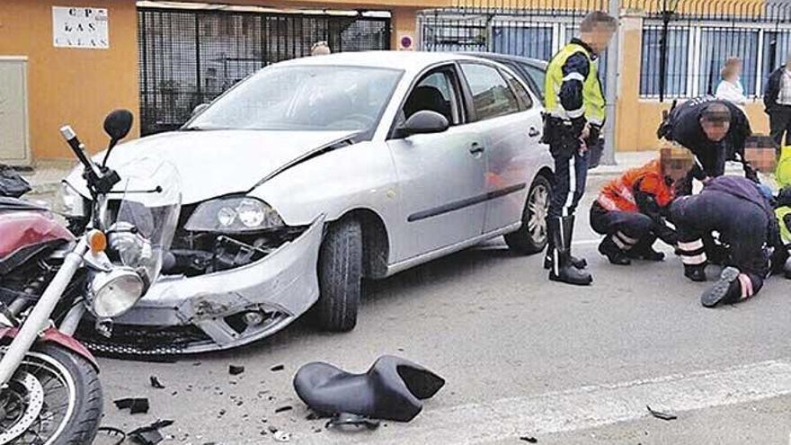 Policías y sanitarios atienden al motorista herido.