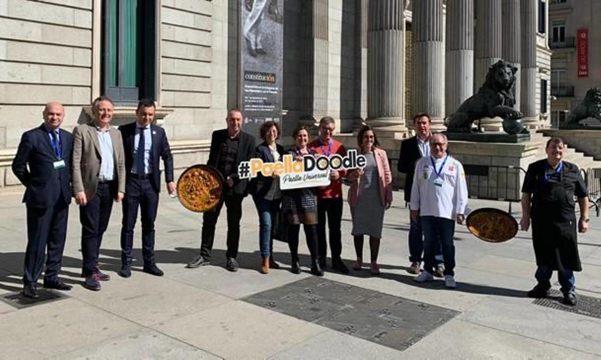 Autoridades de Sueca y diputados con paellas ante el Congreso.