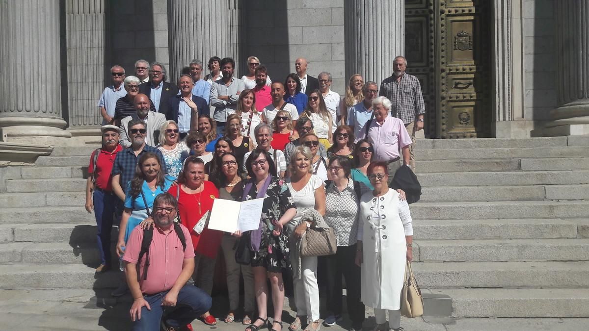 Miembros de las asociaciones de bebés robados junto a varios diputados, esta mañana en el Congreso.