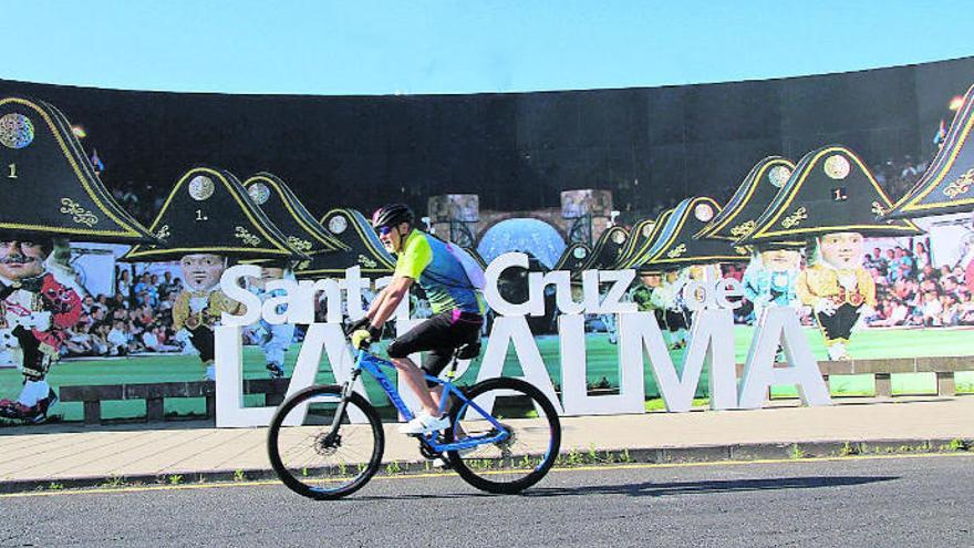 Un ciclista pasa frente al mural alusivo a la Danza de los Enanos en Santa Cruz de La Palma.