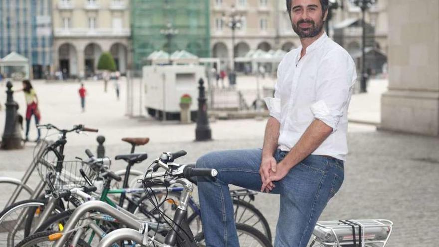 Daniel Díaz, na praza de María Pita, sobre a bicicleta que usa nos seus desprazamentos.