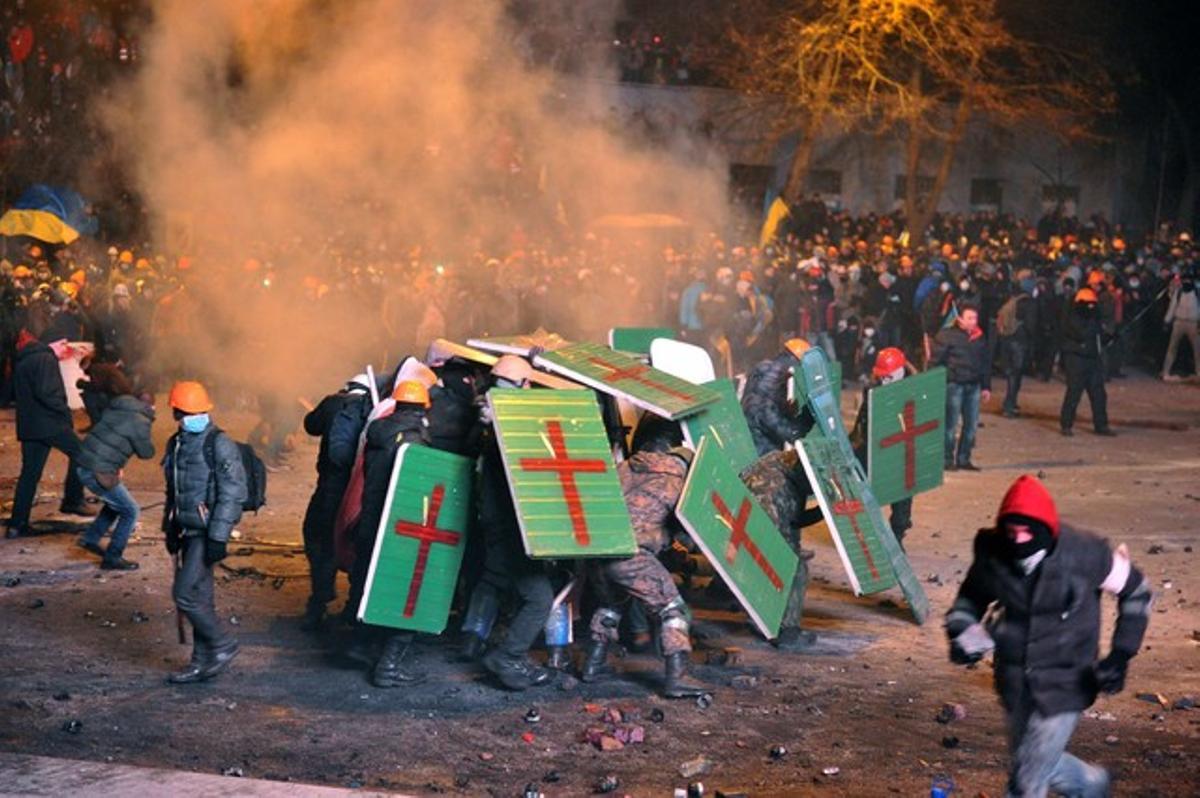 Els manifestants es protegeixen a si mateixos a mesura que xoquen amb la policia antiavalots.