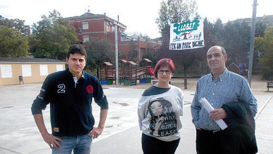 Per l&#039;esquerra, Martín, Bononad i Solernou, al parc Llobet, amb una pancarta reivindicativa penjada al fons