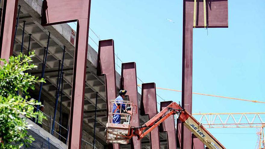 Una grúa y varios operarios, ayer, colocando las vigas de una fachada del Centro Cultural.