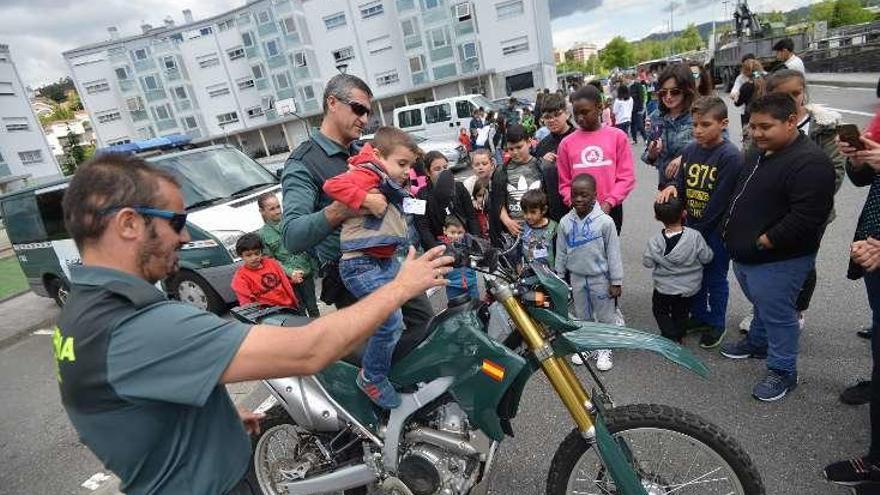 Un niño monta en la moto con la ayuda de un Guardia Civil. // G.S.