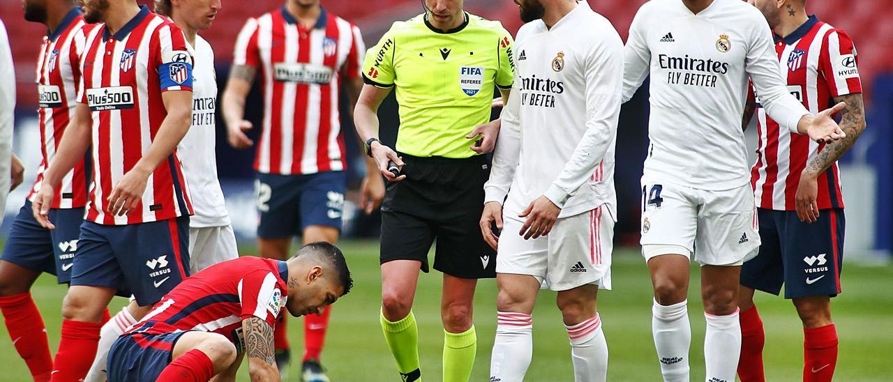 El colegiado lanzaroteño Alejandro Hernández Hernández, el pasado domingo, en el Wanda Metropolitano ante Nacho, Casemiro y con Luis Suárez, en el suelo.   | | EUROPA PRESS