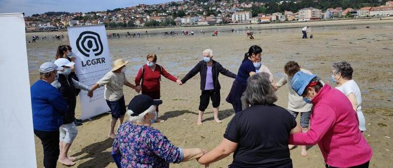 Usuarias de Afamo en el proyecto de terapia musical con el apoyo de las mariscadoras. |   S. ÁLVAREZ