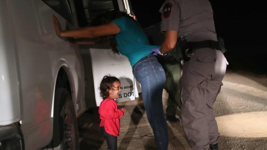 La niña hondureña llorando junto a su madre.