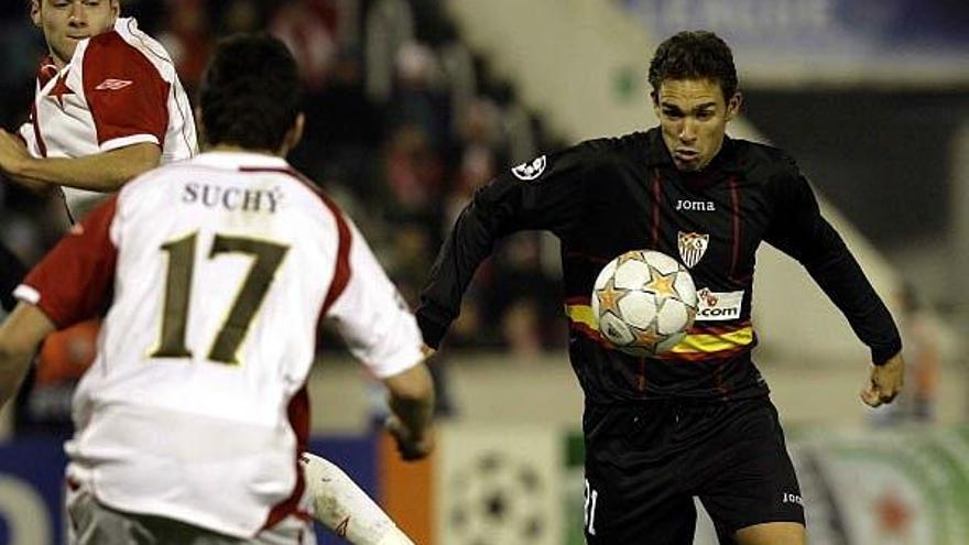 Lolo, a la derecha, controla un balón en un partido con el primer equipo del Sevilla.